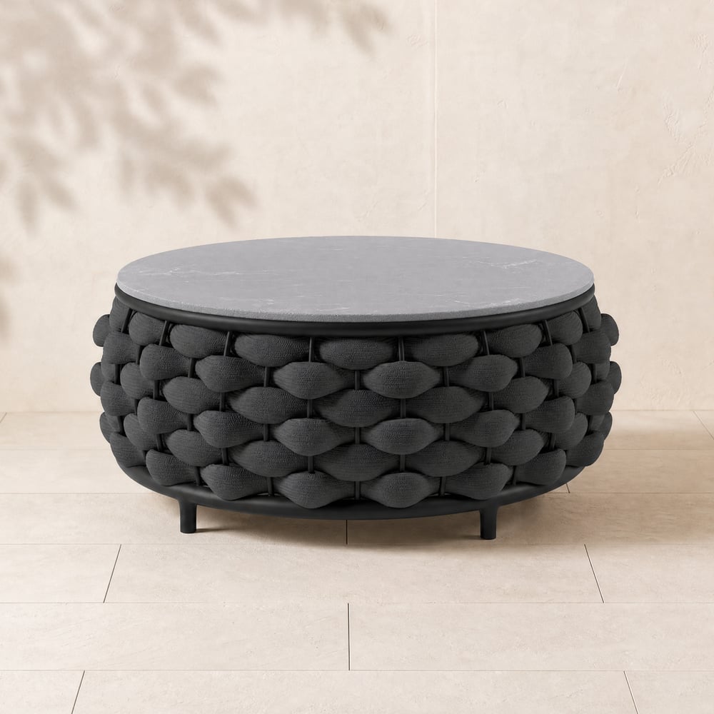 Mesa de centro redonda de exterior Cocaro Modern de mármol sintético con base de cuerda trenzada en negro Imagen de ventana