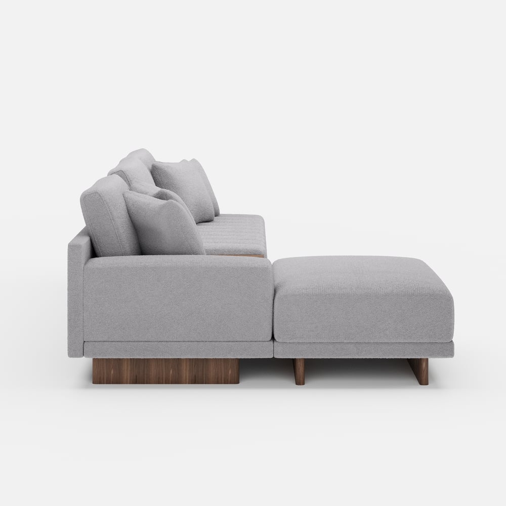 Sofá modular en forma de L Vewal de 320 cm en tela bouclé con chaise longue y otomana Imagen de ventana