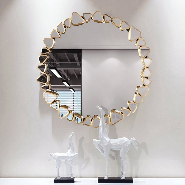 Modern round wall mirror with gold geometric frame and pebble details