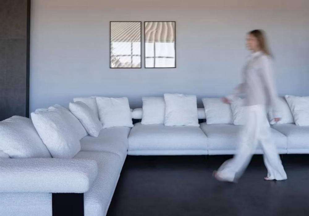 woman-walking-past-a-large-white-sectional-sofa